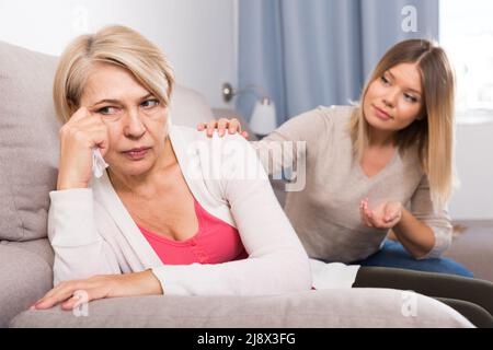 daughter comforts a sad mother Stock Photo