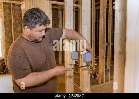 Work on installing electrical outlets mounts in new home Stock Photo