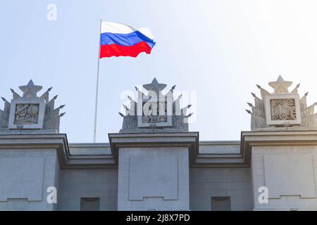 Russian flag. State flag of the Russian Federation against the blue sky. The banner of the country on the building. Stock Photo