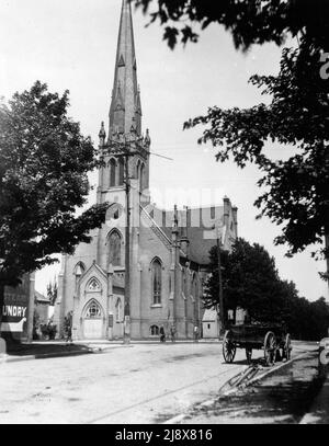 Unknown church in Ontario, opposite a sign for a steam laundry, with a cart and bicycle in the foreground  ca.  1910 Stock Photo