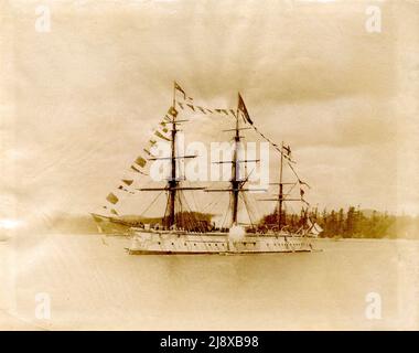 British battleship HMS Triumph dressed. Most likely on the occasion  of the official opening of the Canadian Pacific Railway in Vancouver harbour in 1887 for both ceremonial reasons and protection against a rumoured Fenian attack.  ca.  1887 Stock Photo