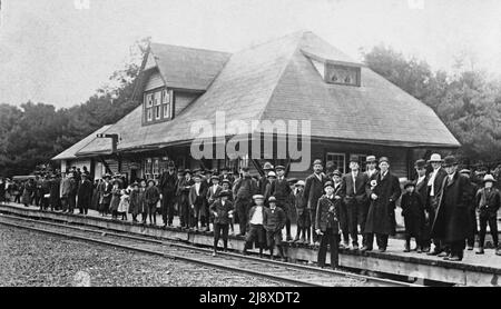 A crowd gathers on the Central Ontario Railway platform in Bancroft to await the arrival of the first train to that city  ca.  1900 Stock Photo
