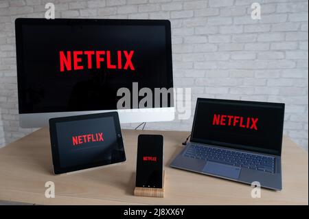 Netflix logo on the screens of all devices. Application for watching movies and TV shows stream right on a smartphone on a laptop, digital tablet and Stock Photo