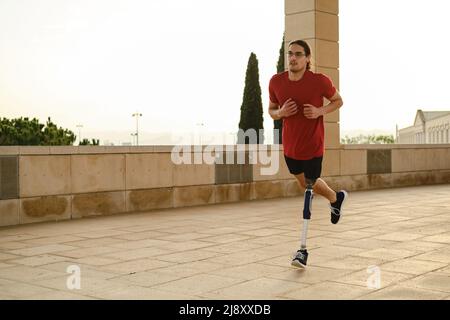 Young male athlete with a disability running outdoors. Stock Photo
