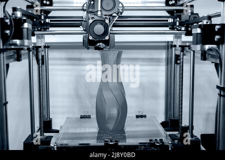 Process printing model on 3d printer. High tech digital printer computer machine in action. Printing mechanism adding layers to object. FDM 3d printer working at 3d printing lab. 3D modern technology. Stock Photo