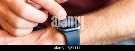 02.23.2022 Moscow. male hand with wrist smart apple watch. young man people using modern technology by adjusting and setting the time on the clock by Stock Photo