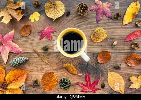 Autumn background with autumn leaves on dark oak wood with mug of black coffee. Top view. Flatlay. Stock Photo
