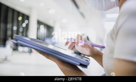 Close-up of a woman's hand using a tablet in the airport. Stock Photo