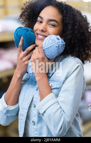 young pretty woman holding many colorful yarn clews Stock Photo