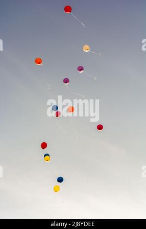 Flying colorful balloons rise in the sky Stock Photo