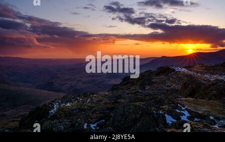 The sun setting over Slight Side (Scafell range) in the English Lake District, UK Stock Photo