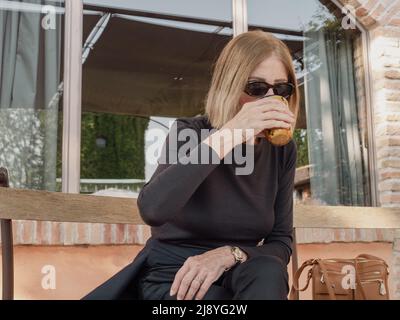 elegant fit lady having espresso coffee outdoors a sunny day Stock Photo