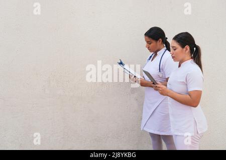 Female nurses using digital tablet in hospital corridor Stock Photo
