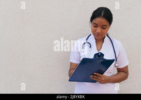 Portrait of a young latina doctor taking notes Stock Photo