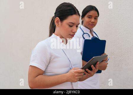 Female doctors using digital tablet in hospital corridor Stock Photo