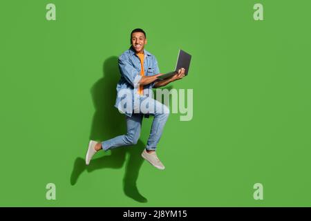 Full size profile side photo of intelligent young businessman working on new project isolated on green color background Stock Photo