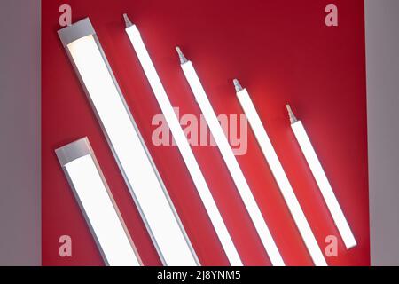 Set of neon LED lamps. Saving energy lamps on a red ceiling. Stock Photo
