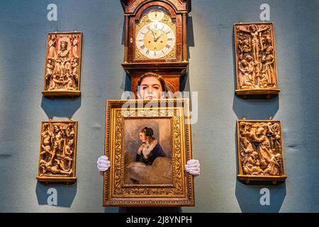 London UK, 19 May 2022. Group of alabaster reliefs, late 15th century - New Testament stories. Estimate (lower right) £40,000-60,000. Christies art handler holds a SIR EDWIN HENRY LANDSEER, R.A. (1802-1873), Portrait of Catherine Seyton, estimate £12,000-18,000 in front of a John Ellicott, London, circa 1740 George II striking longcase clock with barometer. Estimate: £40,000-60,000. Credit amer ghazzal/Alamy Live News Stock Photo