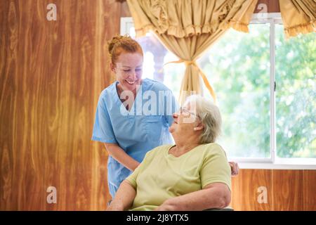 Geriatric nurse in conversation with a senior citizen in a nursing home or in an assisted living facility Stock Photo