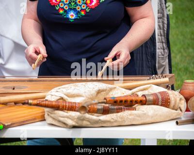 Musician woman plying tsymbaly ethnic musical instrument striking two beaters. Ukraininan version of the hammer dulcimer, chordophone trapezoidal box