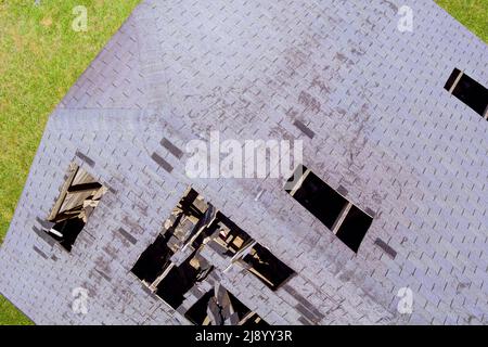 Damaged tiled roofing with broken tiles and a hole on the roof Stock Photo