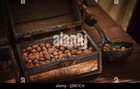 Scandinavian baked breaded almond nuts with cinnamon, garlic, pepper, sugar in vintage chest. Tallinn, Estonia Stock Photo