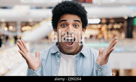Male portrait emotions enthusiastic surprised shocked amazed man african american guy teenager looking at camera opens mouth and eyes in surprise deli Stock Photo