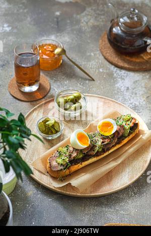Homemade sandwich with turkey, pickles and egg for breakfast, copy space Stock Photo