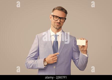 smiling mature man in glasses pointing finger on credit card and thumb up, copy space, call me Stock Photo