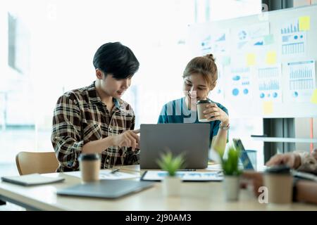 group of young creative asian work cooperate with diverse team at office briefing, focused biracial businessman head meeting, collaborate discuss Stock Photo