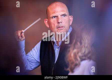 19 May 2022, Mecklenburg-Western Pomerania, Peenemünde: Jaap van Zweden conducts the New York Philharmonics during a rehearsal in the former turbine hall at the Historisch-Technisches Museum Peenemünde on the island of Usedom. After almost a year and a half without concerts due to the Corona pandemic, the orchestra makes a guest appearance on the Baltic Sea. The New York Philharmonic Orchestra will give concerts in Peenemünde on May 20, 21 and 22, 2022. Photo: Jens Büttner/dpa Stock Photo