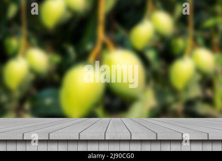 Empty wooden table with blur mango farm backgrounds Stock Photo