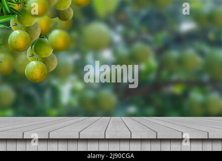 A wooden table with oranges or sweet lime hanging on tree background. For display your products. Stock Photo