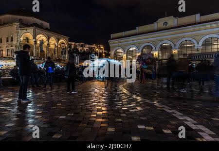 Athens Old Town, Attica, Greece - 12 28 2019 Locals and tourists walking over the Monastiraki Square by night Stock Photo