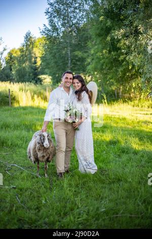 stylish happy bride putting on earrings and smiling, rustic wedding morning preparation in home. bridal getting ready. emotional moment. space for tex Stock Photo