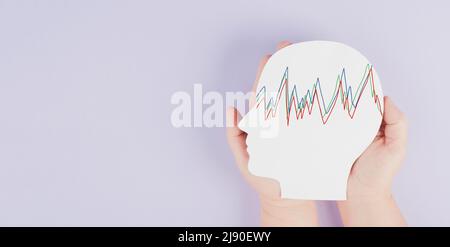 Holding a head in the hands, epilepsy disorder awareness, brain waves,mental health care, paper cut out, purple color Stock Photo