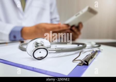 Close-up of stethoscope is lying on the clipboard in front of  a doctor. Stock Photo
