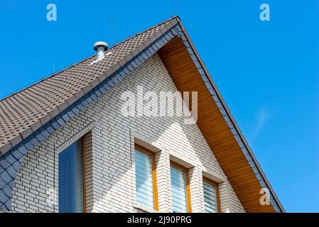 The church has a classic PVC soffit that imitates wood with a white brick facade. Stock Photo