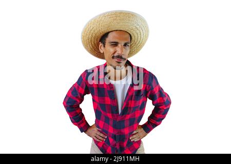 Man With Hat and Junina Party Shirt Isolated on White Background. Young man wearing traditional clothes for Brazilian June festival. Stock Photo