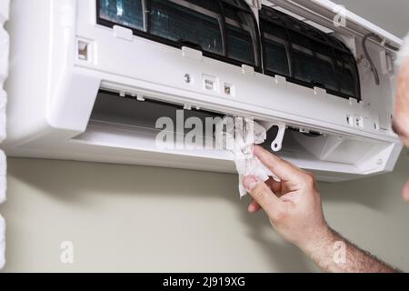 the master washes the home air conditioner inside with a rag Stock Photo