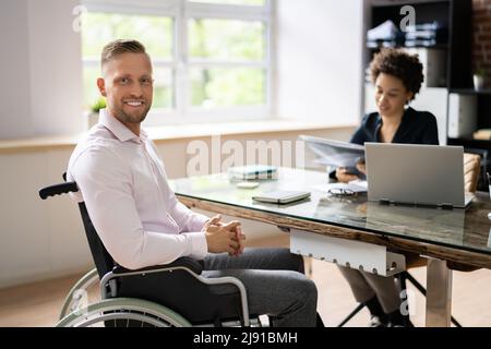 Happy Disabled Businesswoman Working On Laptop In Office Stock Photo