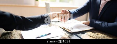 African Man And Middle Eastern Woman Shaking Hands At Interview Meeting Stock Photo