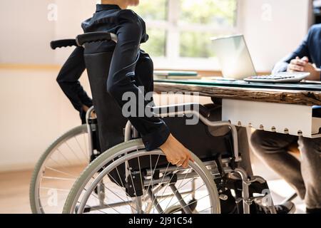 Disabled Businesswoman Sitting On Wheelchair In Office Stock Photo