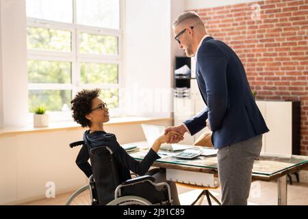 Two Happy Businesspeople In Office Shaking Hands Stock Photo