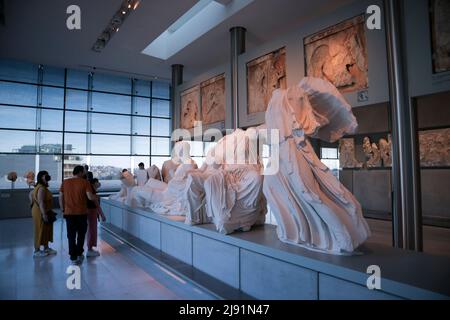 Visitors pass by the replicas of the Parthenon sculptures (plaster copies of the Elgin marbles) at the Parthenon floor in the Acropolis museum. Tourists and locals visit the Acropolis Museum in Athens and enjoy free entrance as part of the celebrations on International Museum Day. Credit: Dimitris Aspiotis / Alamy Stock Photo