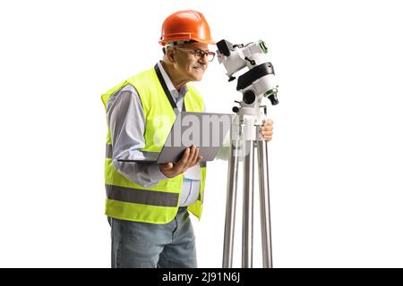 Geodetic surveyor measuring with a positioning station and holding a laptop computer isolated on white background Stock Photo