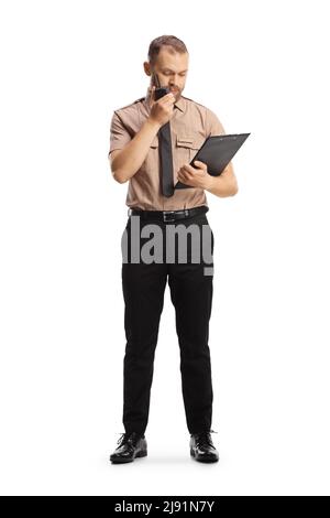 Full length portrait of a security officer holding a clipboard and using a walkie talkie isolated on white background Stock Photo
