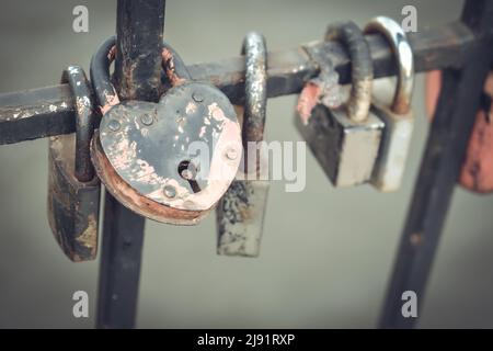 Locks of love on the railing in the city park. Many locks of love hang on a metal fence in a city park Stock Photo