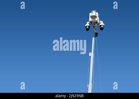 CCTV camera towers in the sky from a mobile surveillance unit in a parking lot Stock Photo