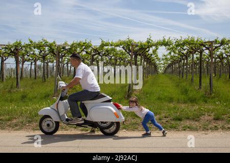 image of an adorable little girl helping dad to push the bike that won't turn on Stock Photo